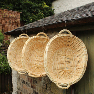 Willow wet linen washing baskets hanging on old building 
